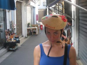 Liz modeling a chapeaux in the flea market