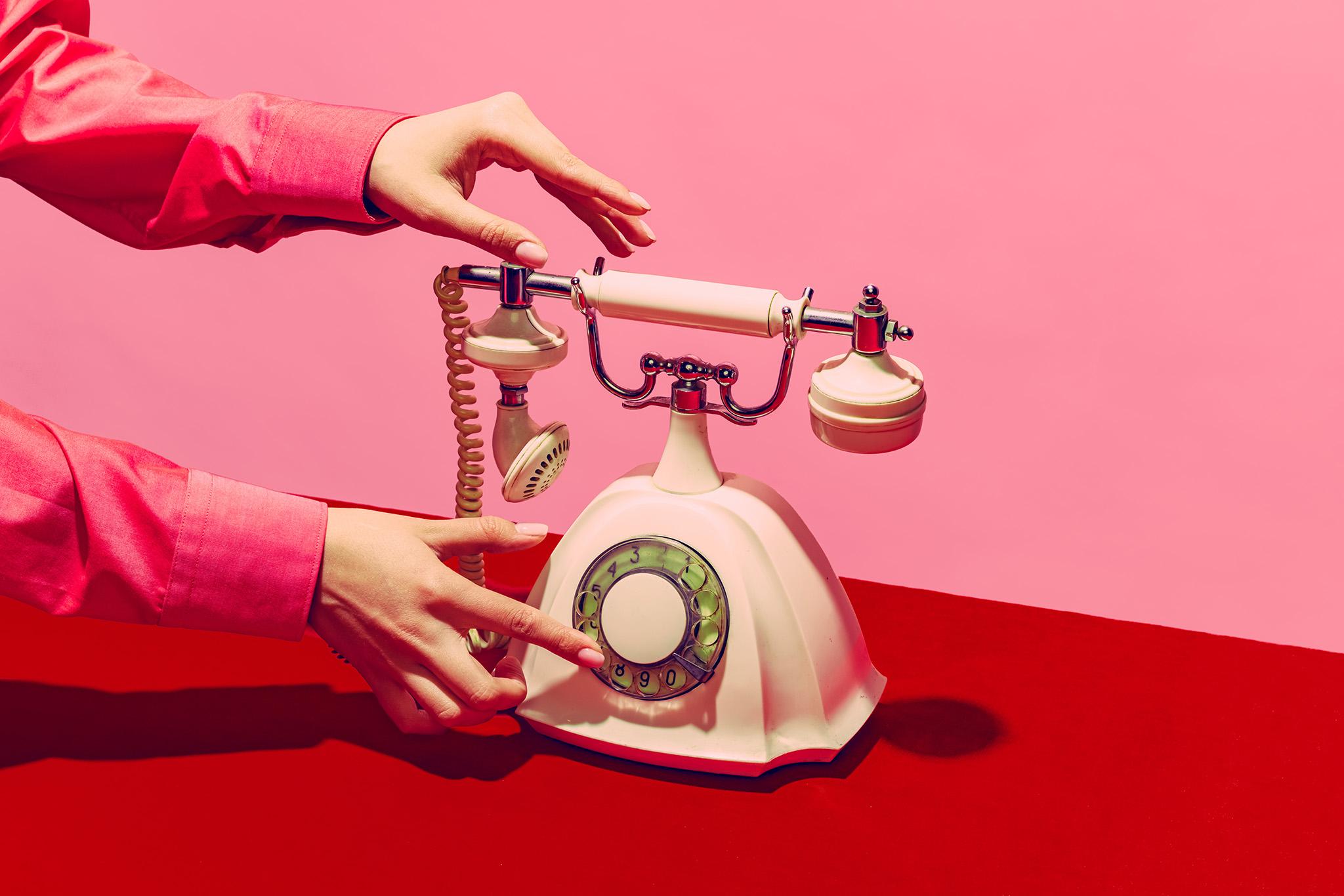 Adobe Stock Image of a hand on a rotary telephone